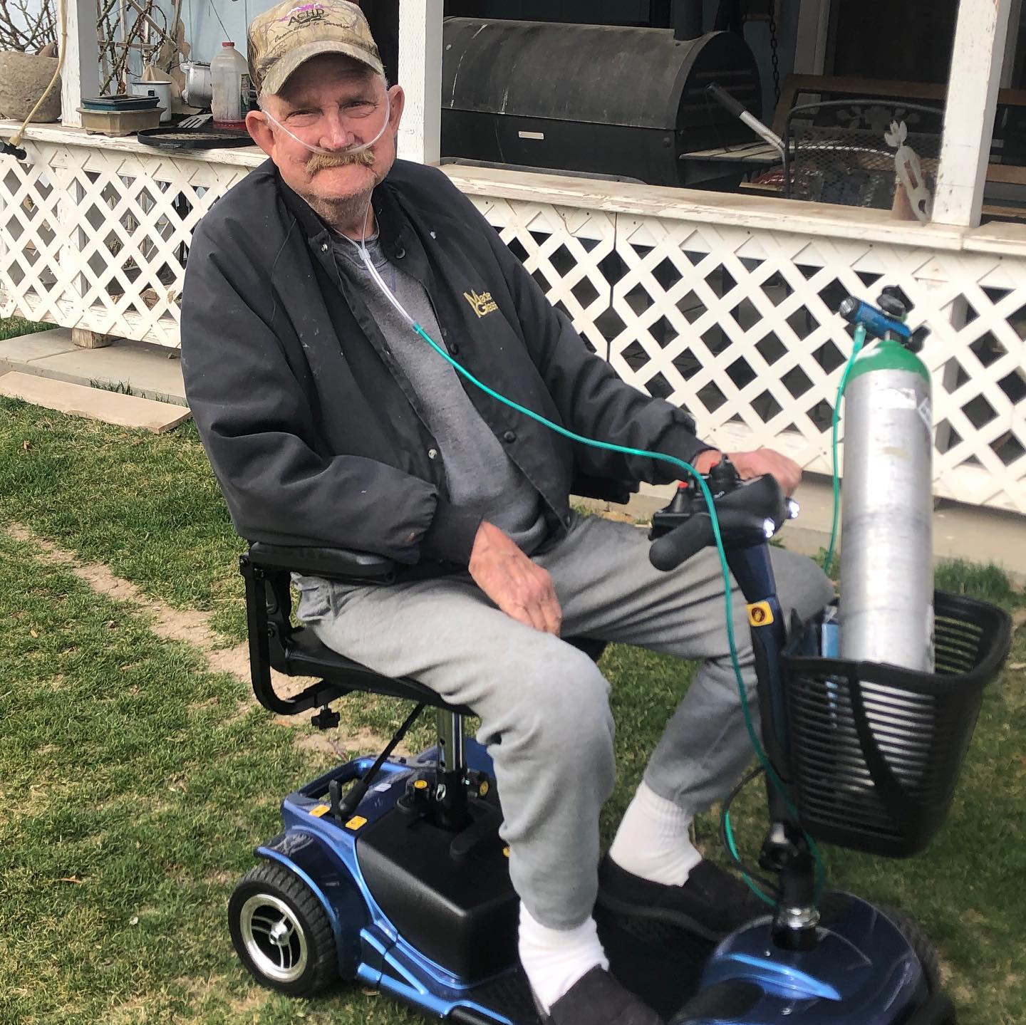 Older gentleman sitting on a power chair wearing oxygen