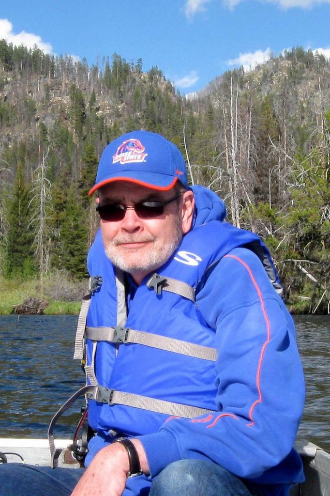 man in life jacket on a boat on the lake