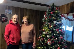 Man and woman standing by Christmas Tree