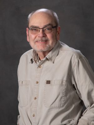 Man with glasses in tan shirt