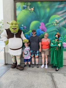 Famly standing next to cartoon characters