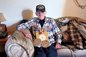 Man sitting on couch with Reel to Reel videos