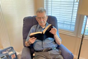 Man sitting in a chair reading a book