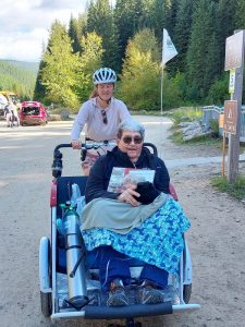 Woman pushing a man on a bike