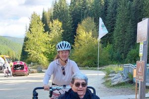 Woman pushing a man on a bike