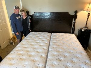 Man and woman standing by a bed