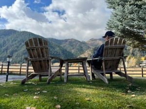 Man sitting in a chair overlooking the mountains