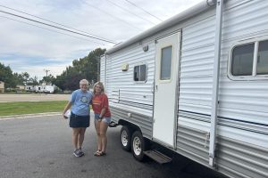 Two women standing next to a trailer