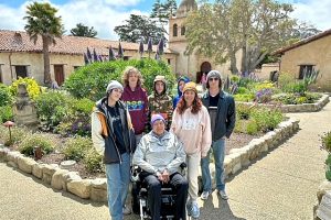 Woman in wheelchair surrounded by family members