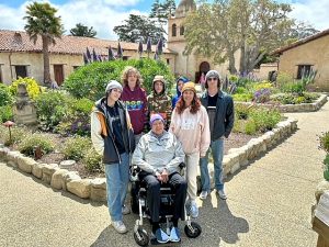 Woman in wheelchair surrounded by family members