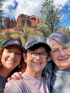 Three women standing in front of rocks in Sedona, AZ