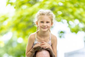 man and girl on shoulders