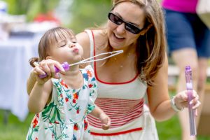 woman with kid blowing bubbles