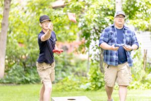 man and boy playing beanbag toss