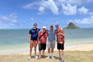 Four men standing on a beach in Hawaii