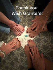 Hands and feet of four women with a Thank You Wish Granters note.