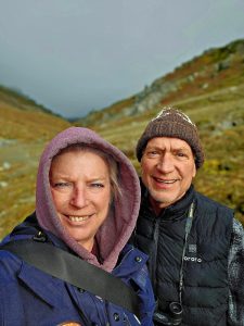 A man and a woman with mountains in the background