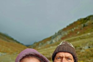 A man and a woman with mountains in the background