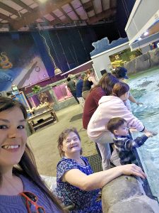 Two women and three children at an aquarium