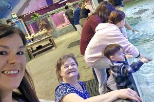 Two women and three children at an aquarium