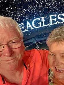 A man and a woman in front of an Eagles sign