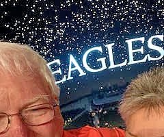 A man and a woman in front of an Eagles sign