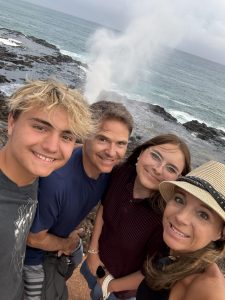 A family of four standing on a beach