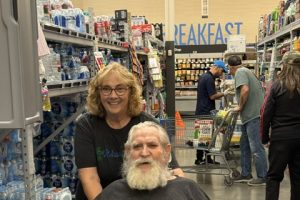 A man in a wheelchair shopping with a woman in Walmart