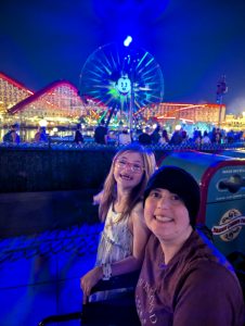 Woman and her daughter in front of Mickey Mouse logo at Disneyland
