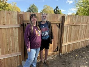 Man and woman standing next to new fence